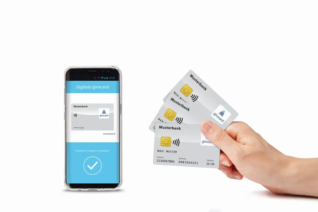 Hand mit mehreren Girokarten und Smartphone, das die digitale Girocard-App zeigt, ideal für kontaktloses Bezahlen und digitale Banklösungen.